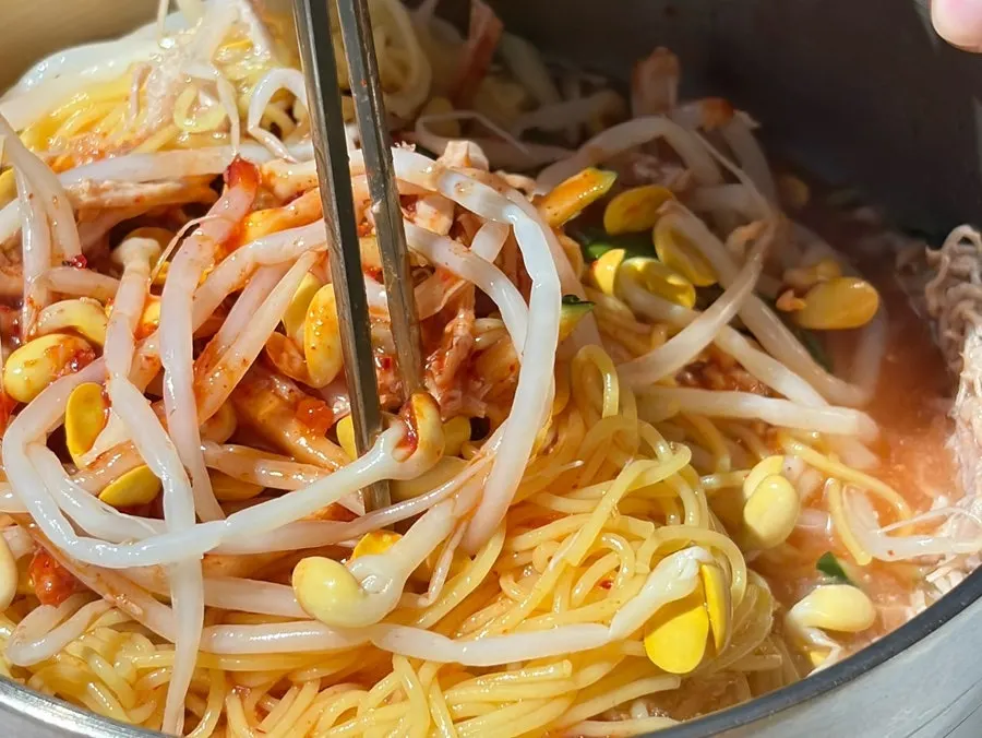 A chopstick-full of mixed bibim noodles lifted up