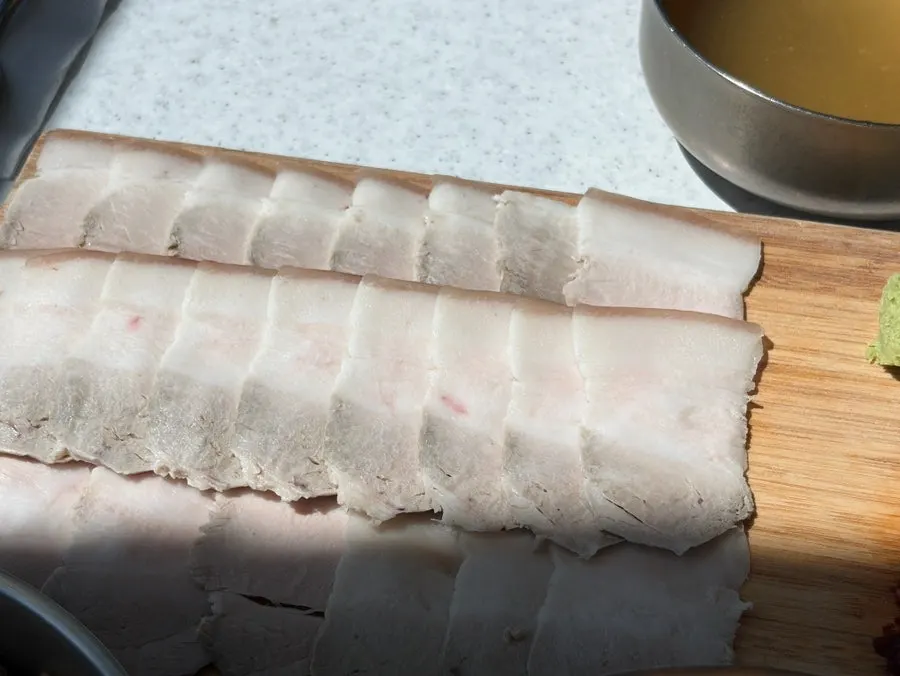 Boiled pork neatly sliced on a wooden board
