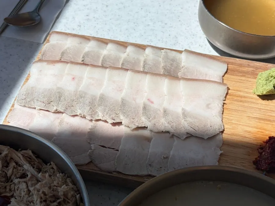 A piece of boiled pork picked up with chopsticks