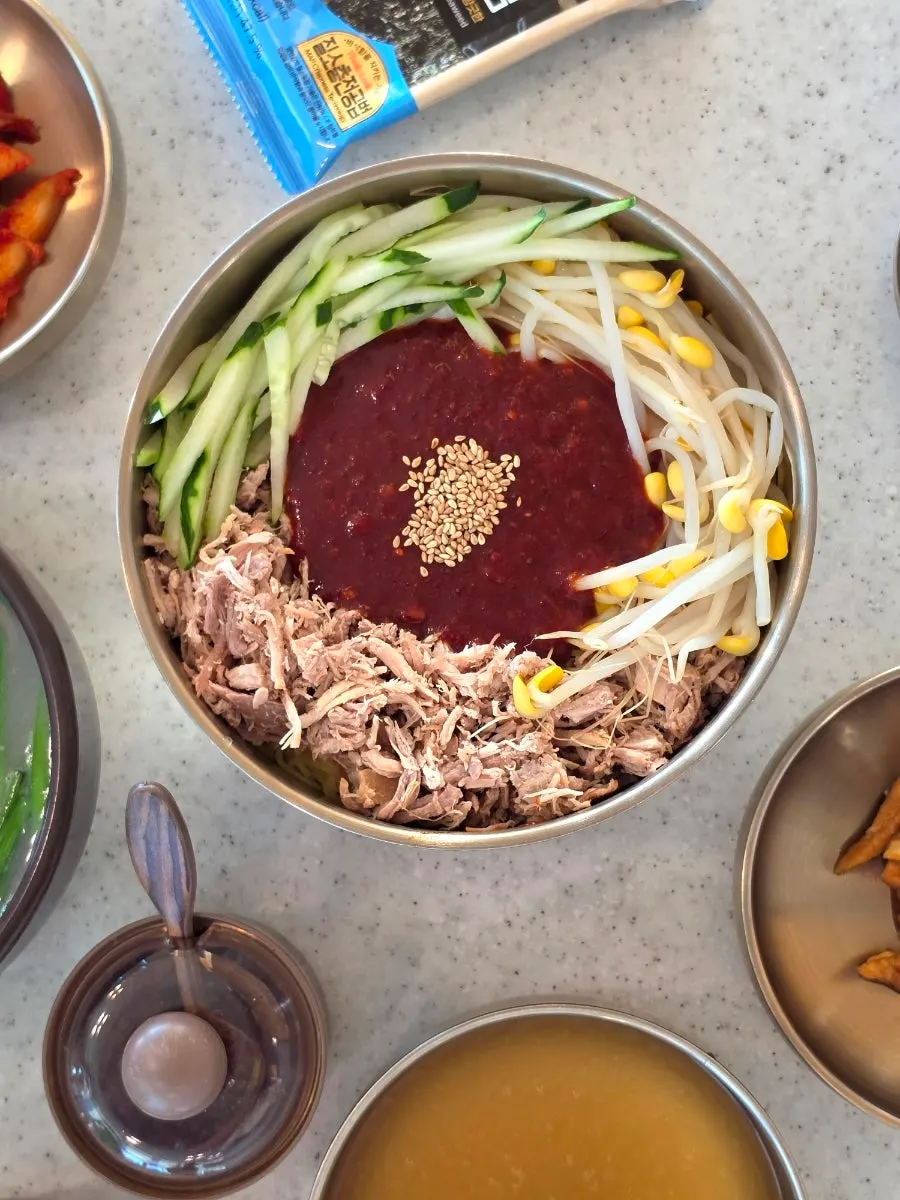 Bibim noodles topped with sauce and pork