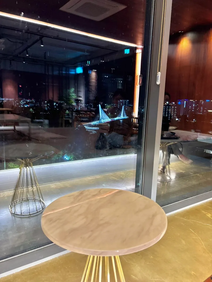 Upper-floor seating at Hands Coffee with seasonal scenery visible