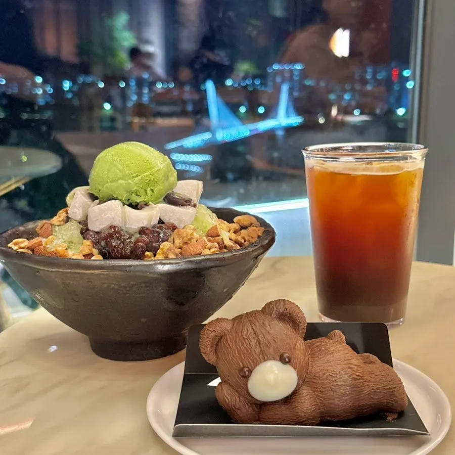 Table spread with green tea bingsu, iced americano, and teddy chocolate cake
