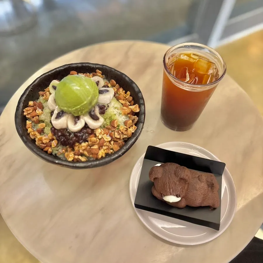 Green tea bingsu topped with green tea ice cream, red bean, and nuts