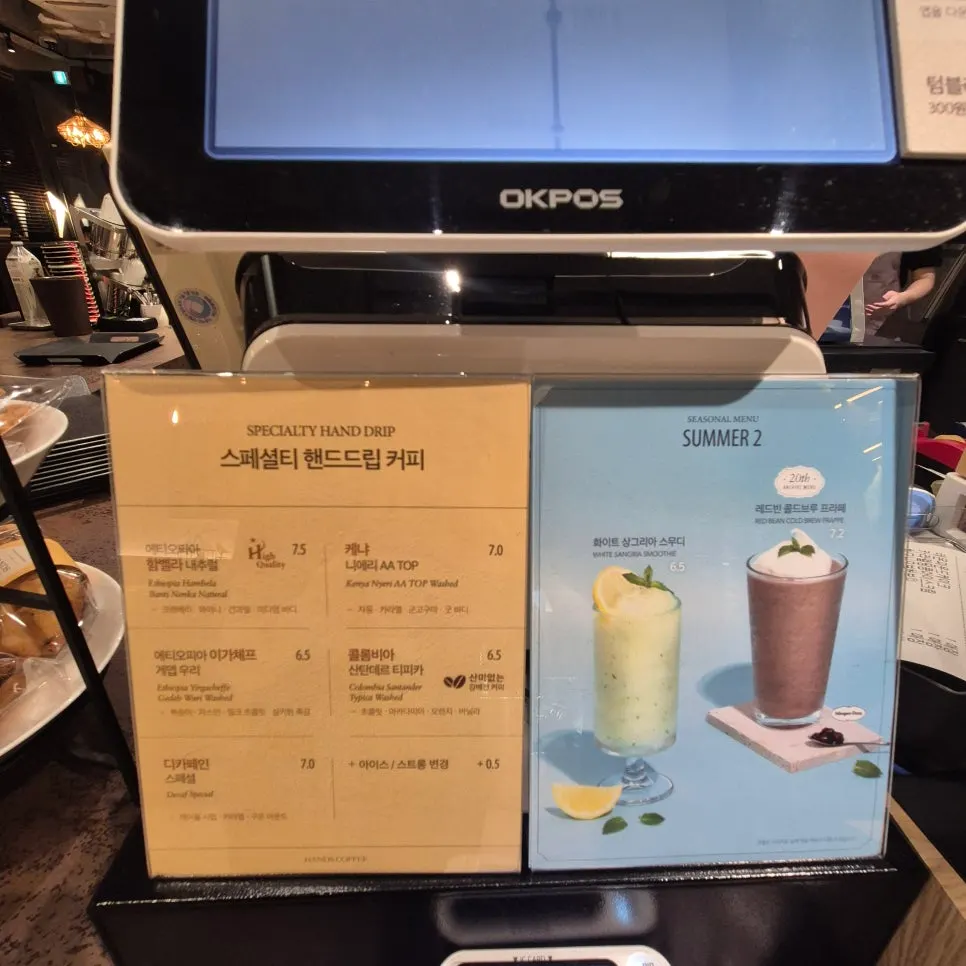 Drink menu board listing fresh juices and lattes