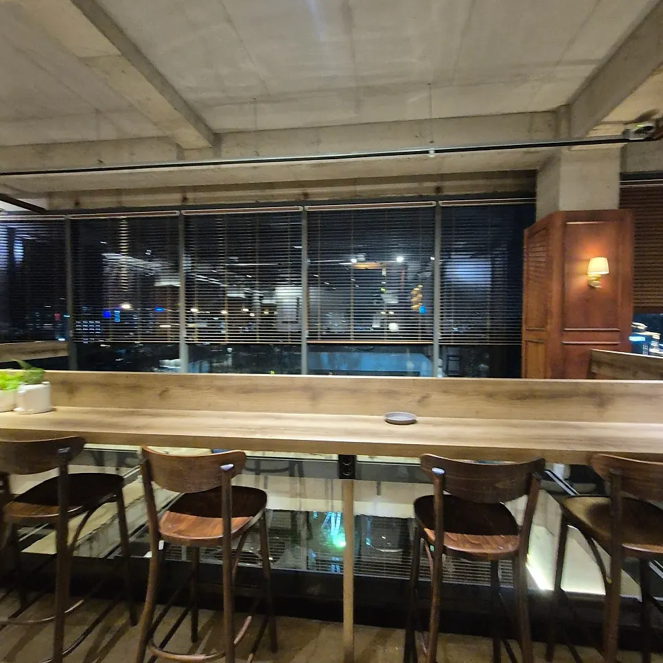 Seating by a table next to the floor-to-ceiling windows