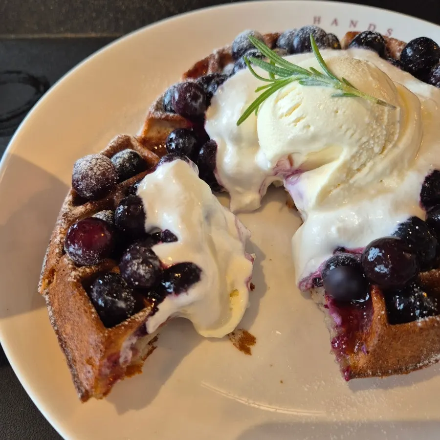 Waffle topped with ice cream and fresh blueberries