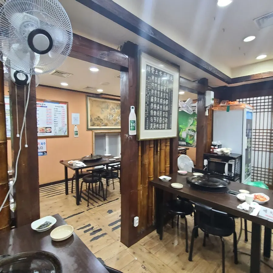 天井のエアコンと扇風機がある店内