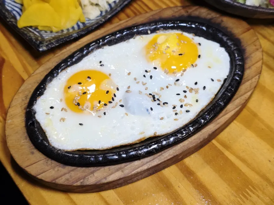 Fried egg sizzling on a hot plate