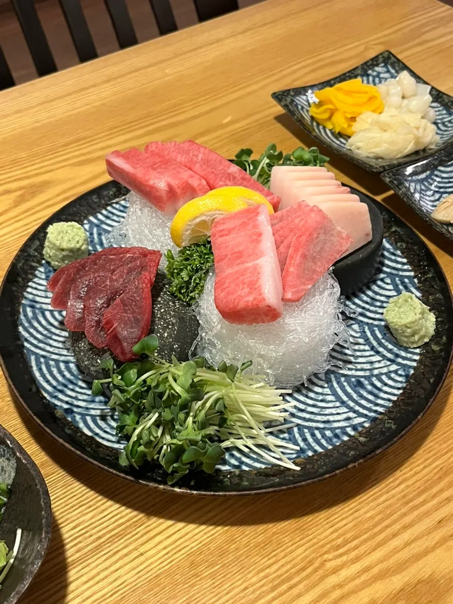 A plate of bright red tuna sashimi with different grain by cut