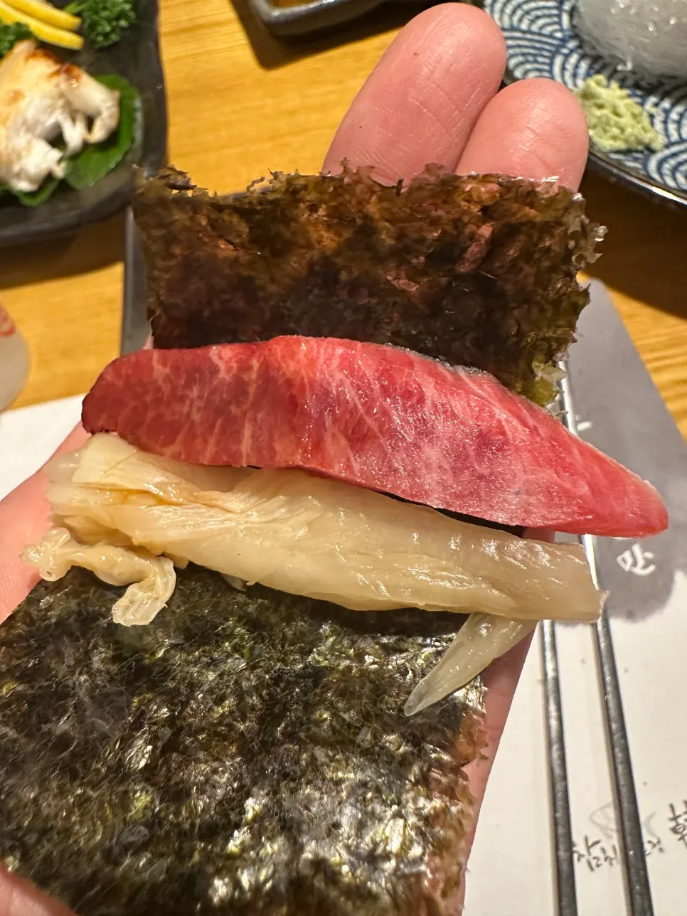 Piece of tuna sashimi topped with radish sprouts and wasabi