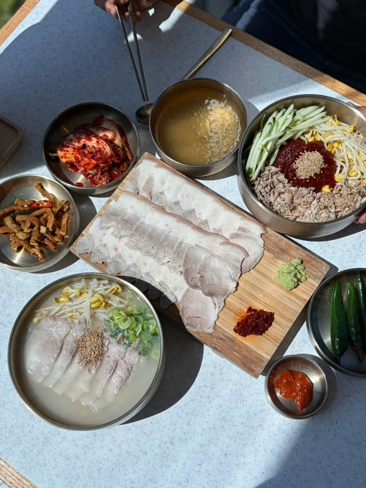 A spread of pork noodles, dongchimi bibim noodles, and cold pork