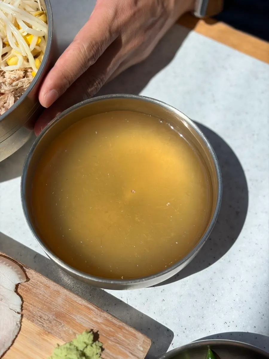 Pouring dongchimi broth into dongchimi bibim noodles