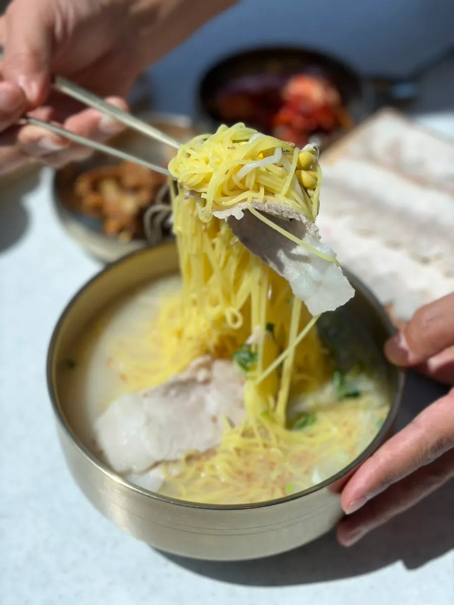 Lifting up the turmeric-mixed thin noodles