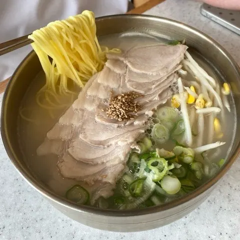 A bowl of pork noodles in milky bone broth