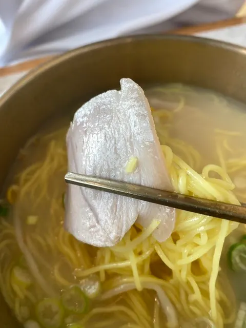Wrapping bibim noodles inside a slice of boiled pork