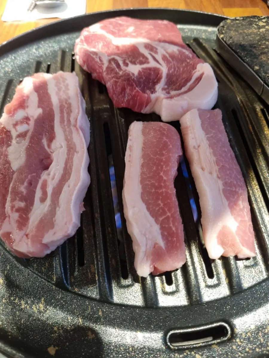 불판에 올린 신선한 돼지껍데기와 삼겹살