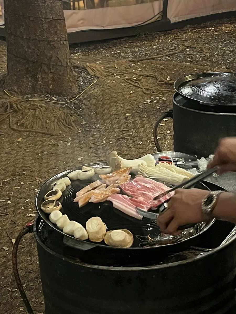 Staff grilling meat at the outdoor table