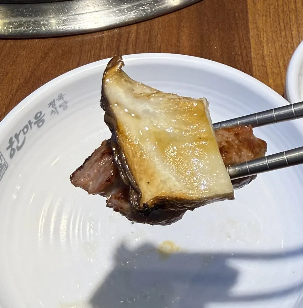 A bite of meat topped with side dish