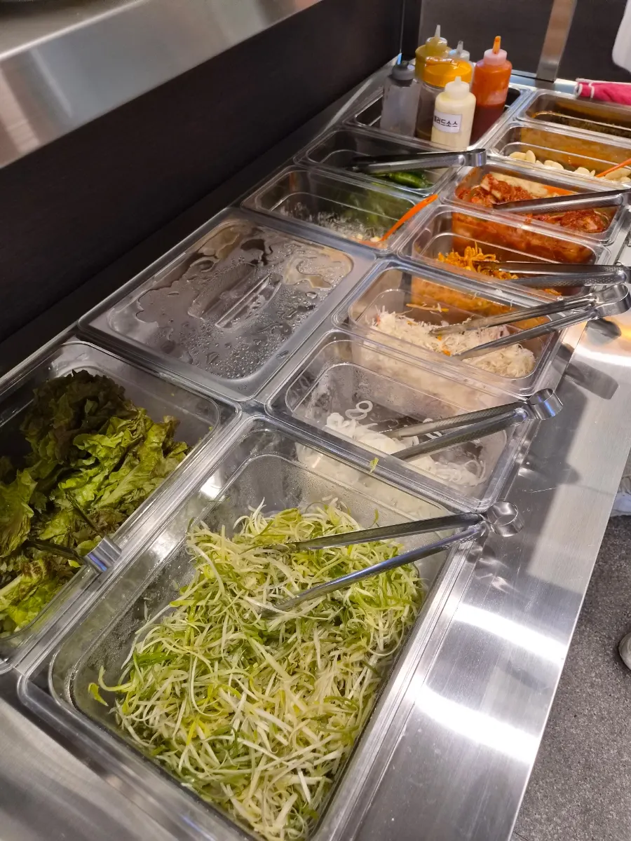 Self-bar stocked with lettuce and shredded green onion