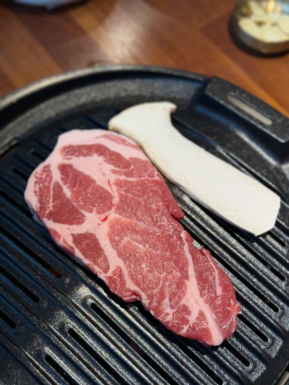 Thick pork belly grilling to a golden brown on the grill
