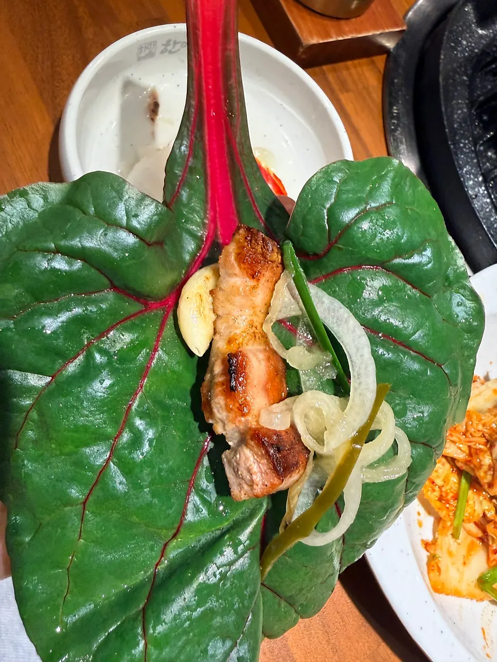 A bite of grilled meat with lettuce wrap