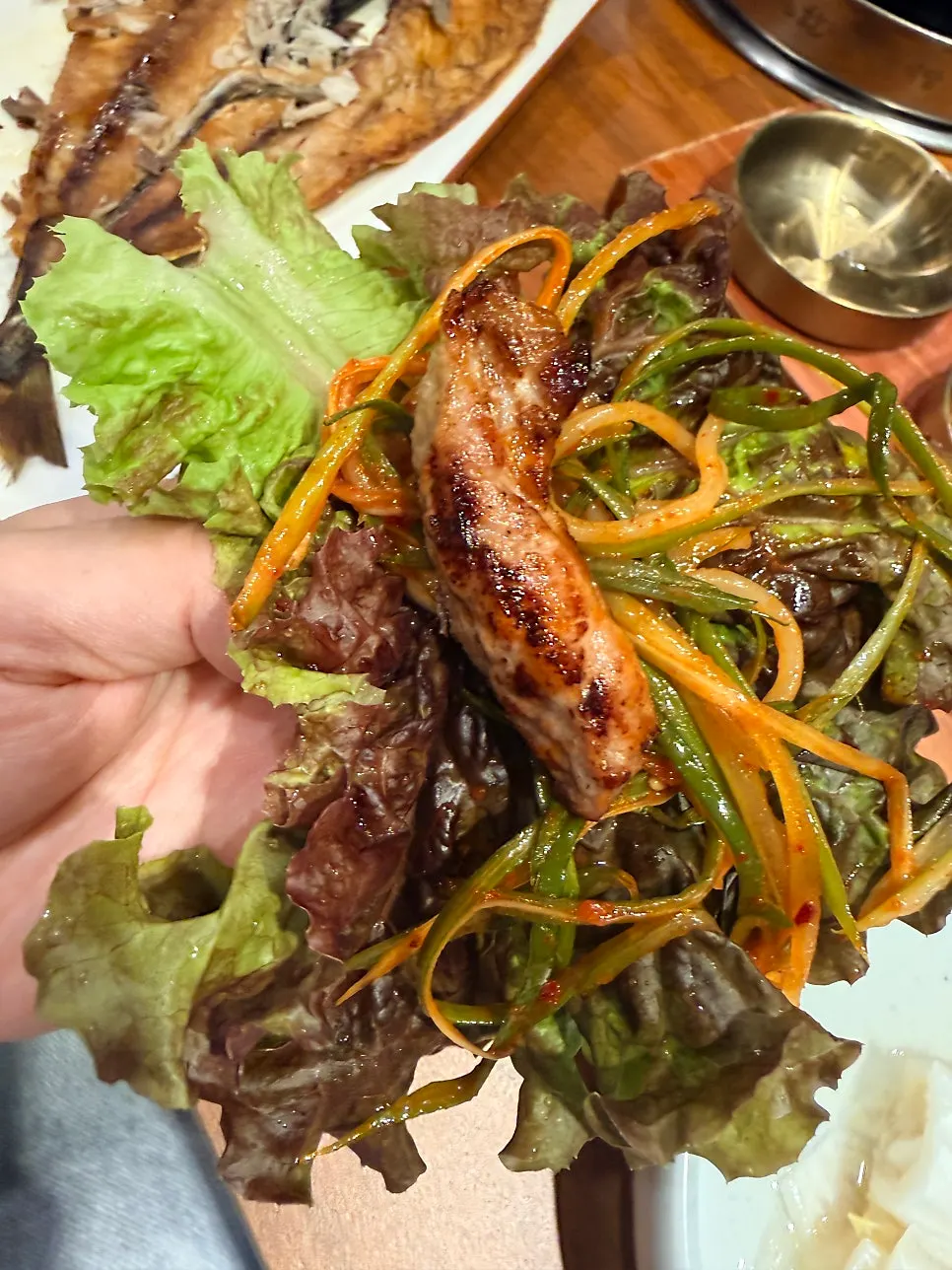 A lettuce wrap topped with garlic and side dishes