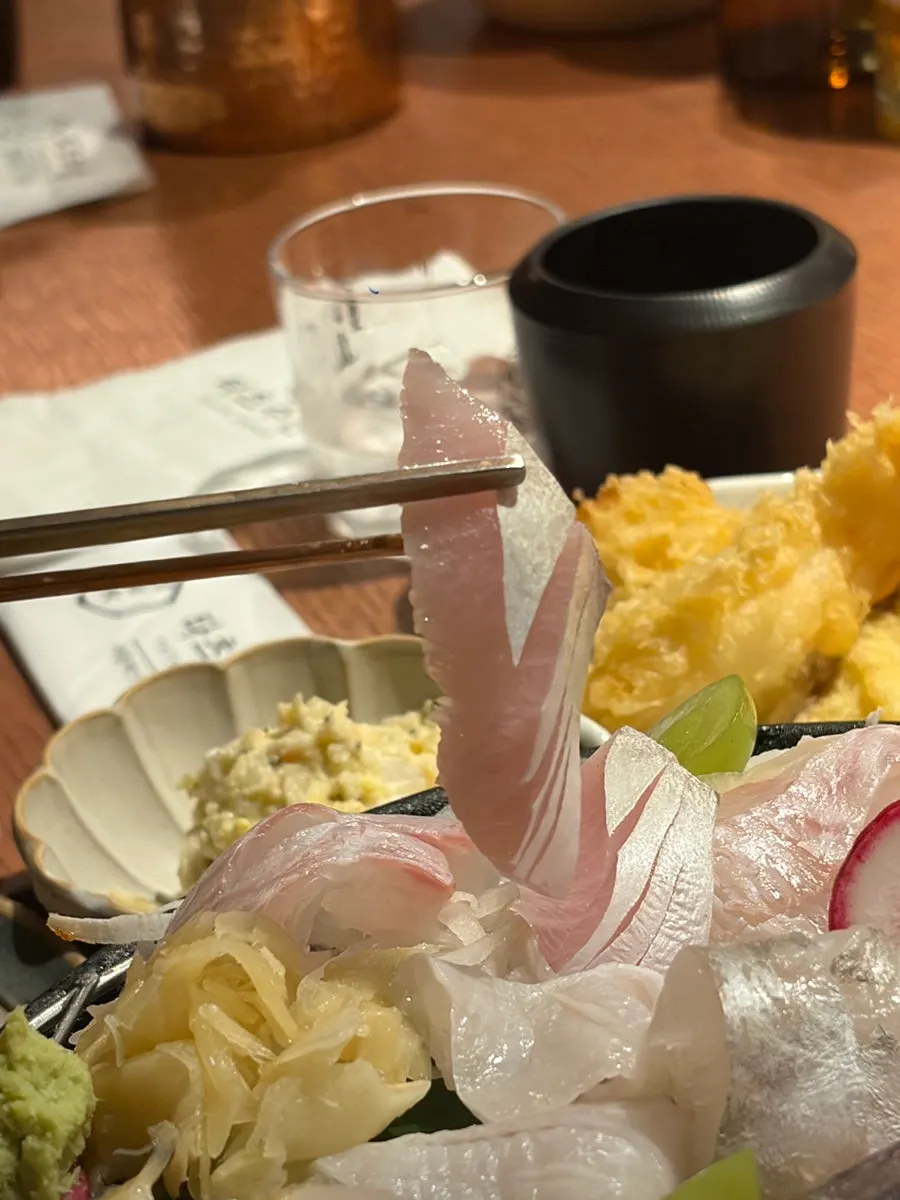 Picking up a piece of aged sashimi with chopsticks