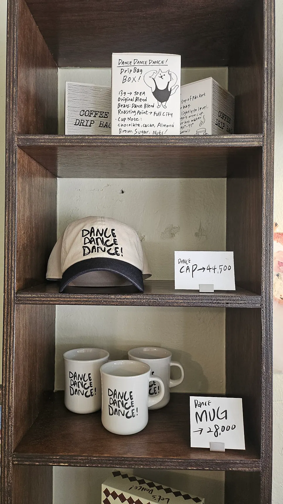 T-shirts, caps, and mugs displayed on shelves