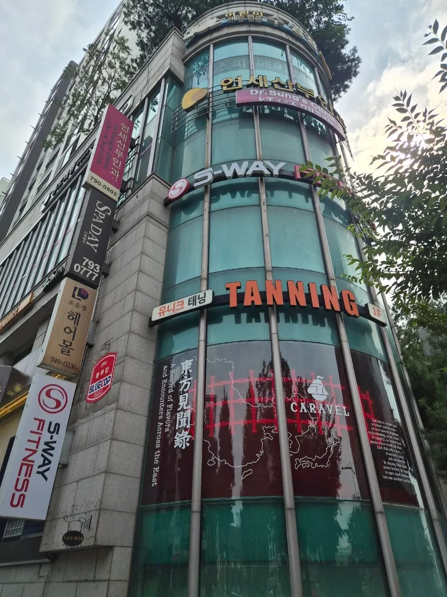 둥근 외관 건물 3층에 자리한 미용실 입구