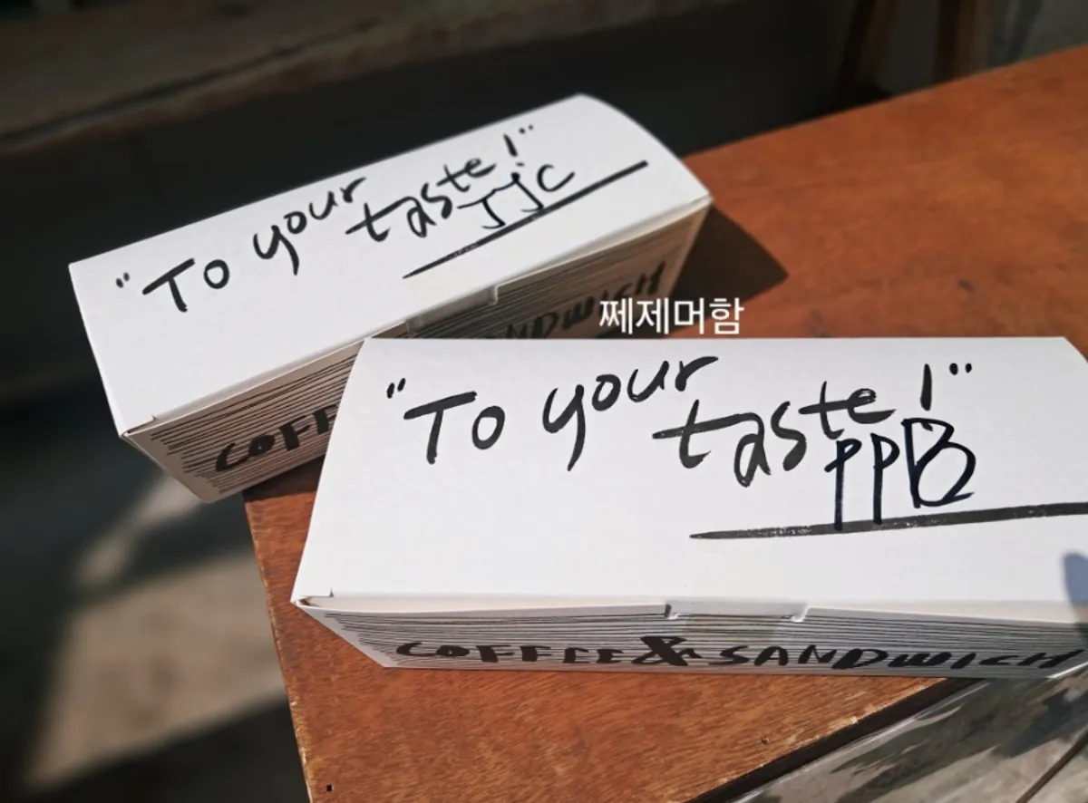 캘리그라피가 그려진 샌드위치 포장박스