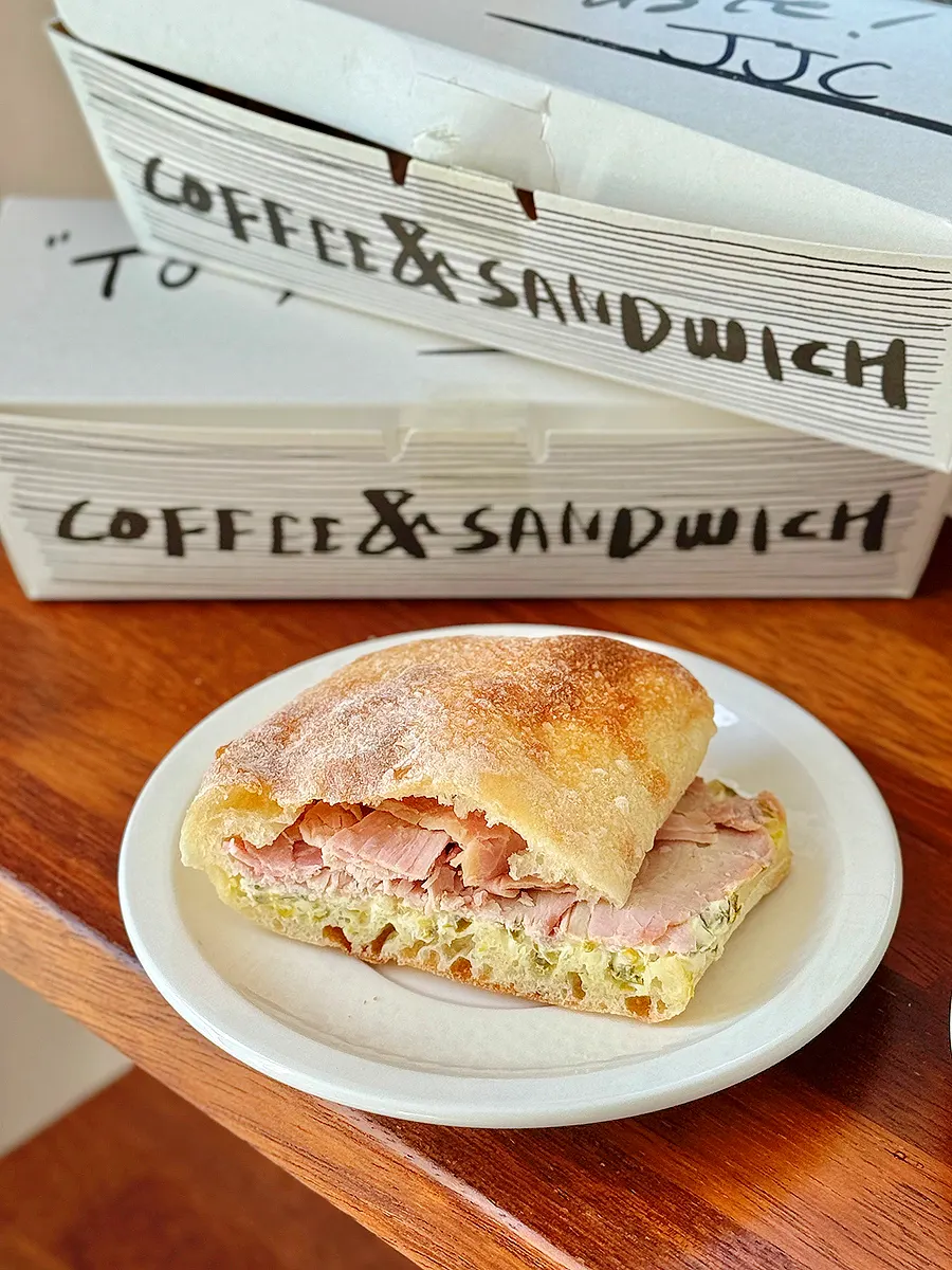 Bite taken out of jambon jalapeño ciabatta sandwich