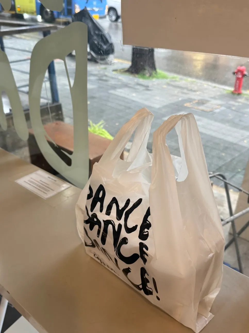 Dance Dance Dance takeout bag with two sandwiches inside