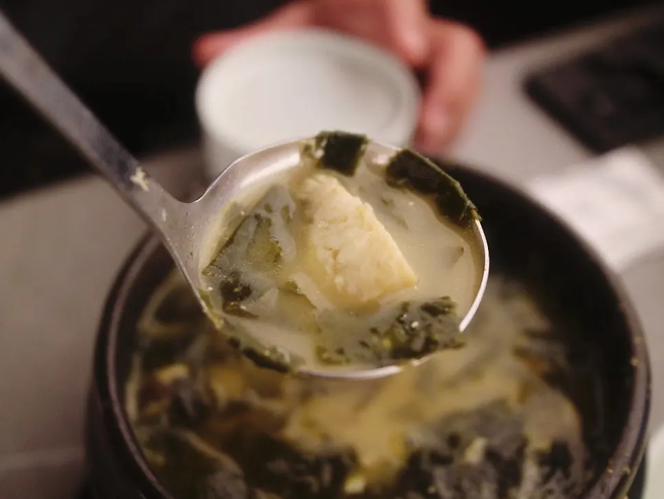 Spoonful of flounder flesh and seaweed