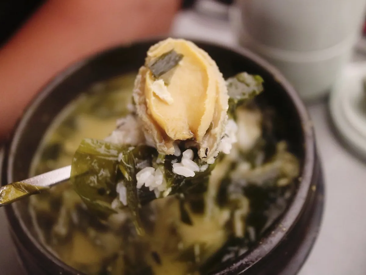 Bowl of abalone flounder seaweed soup packed with ingredients