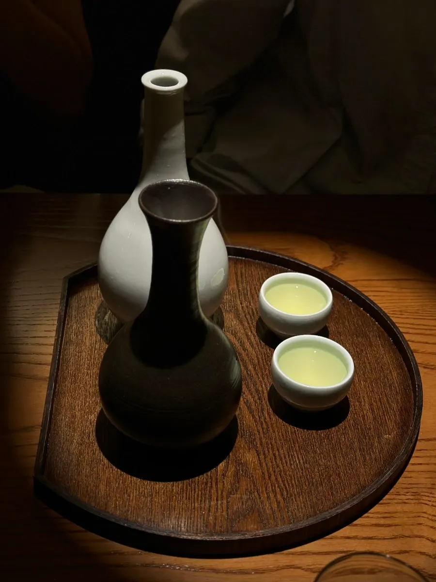 White bottle of liquor and black bottle of fragrance