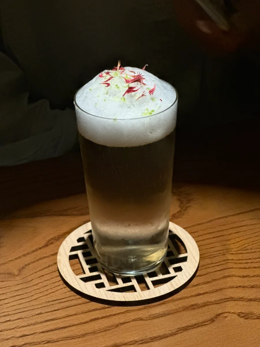 Dongbaek cocktail topped with a camellia flower