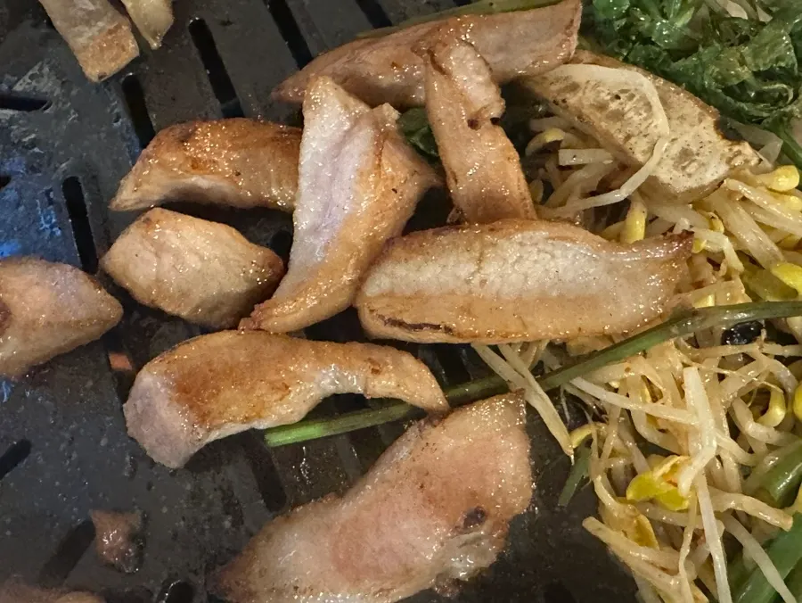 초벌된 삼겹살과 미나리, 콩나물이 올라간 불판