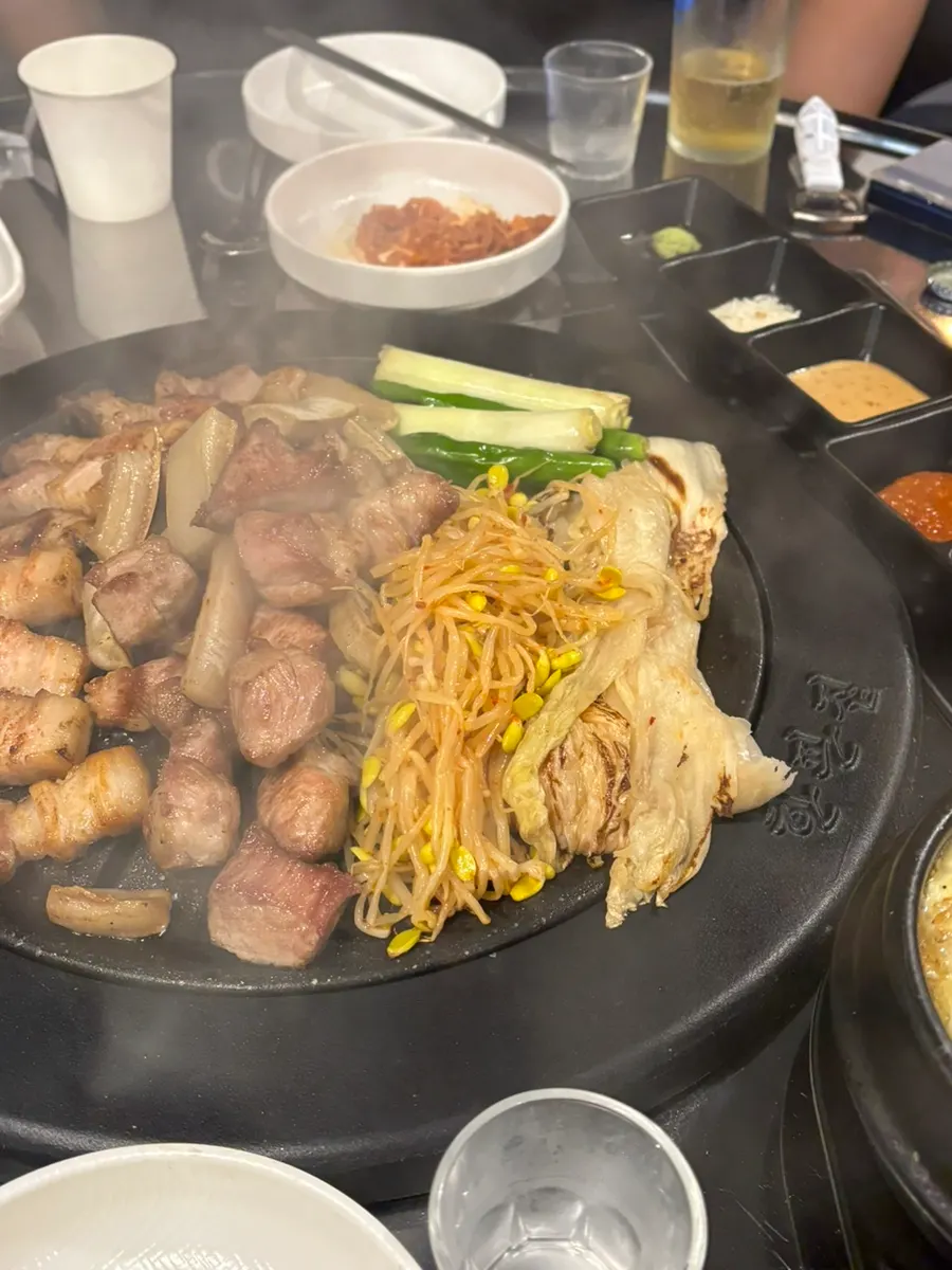 Meat on the grill with white kimchi, scallion and bean sprouts