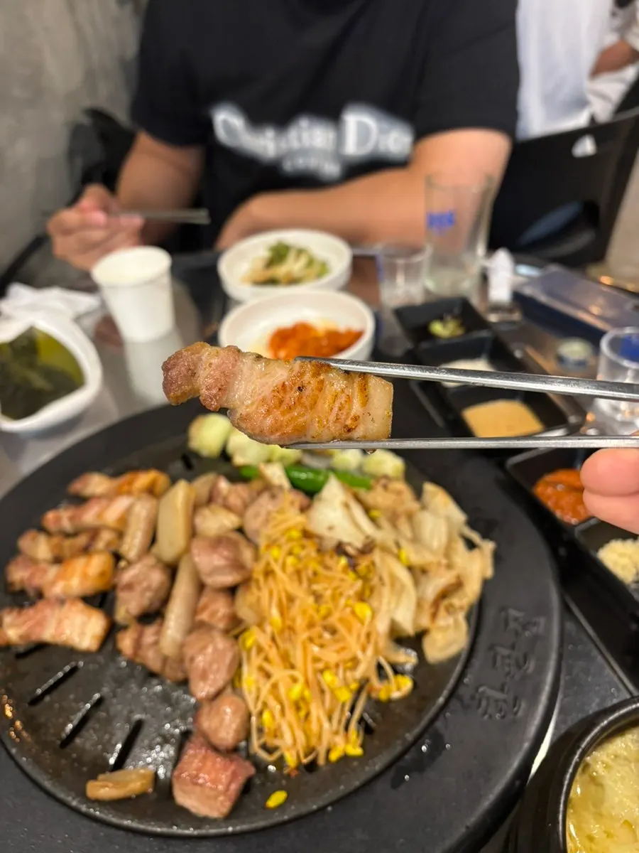 A piece of meat paired with bean sprouts and white kimchi