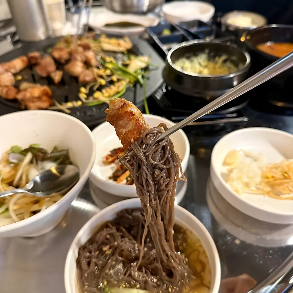 Table with both pork and naengmyeon enjoyed together