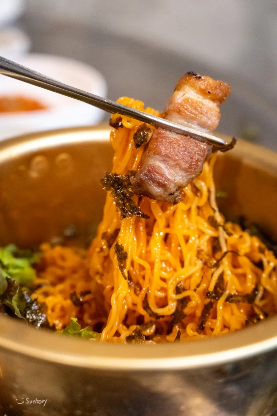 Spicy bibim noodles paired with pork belly