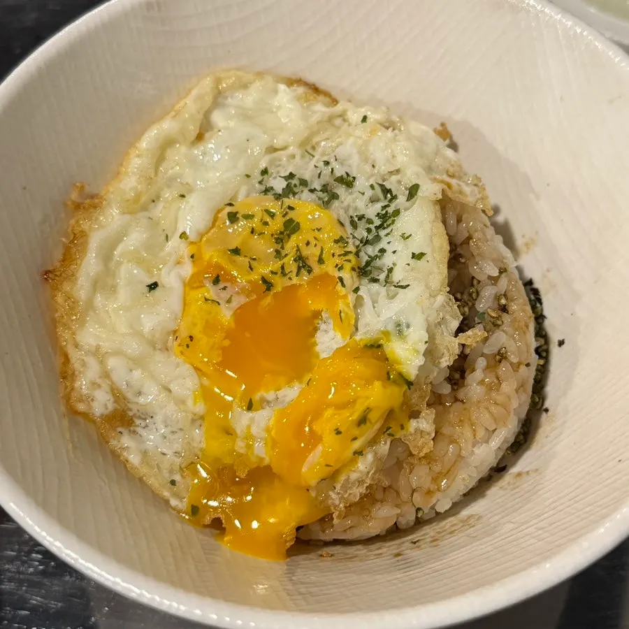 Close-up of butter melting over soy sauce egg rice