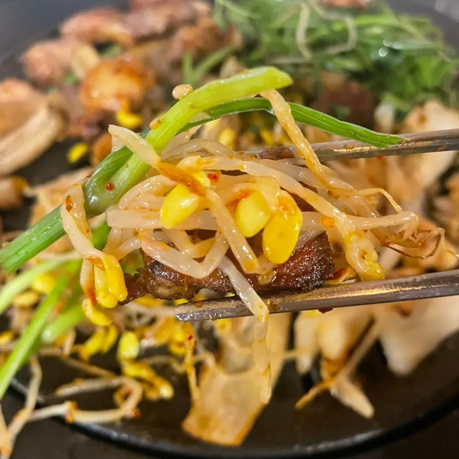 Piece of pork paired with peanut-curry sauce and wild garlic leaves