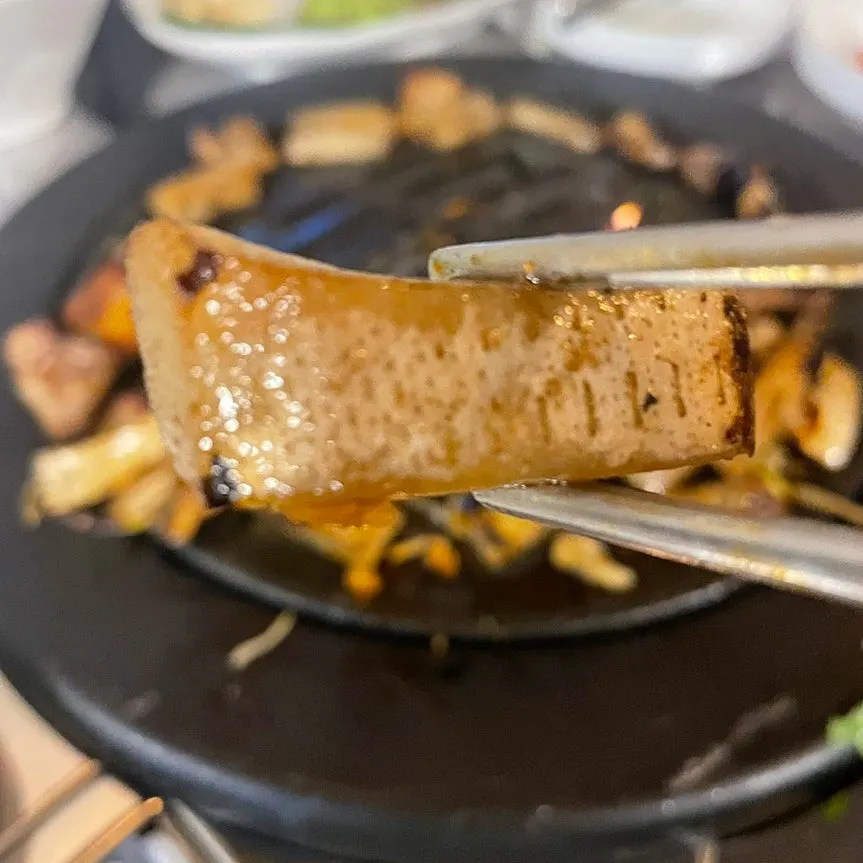 Chewy pork skin layered underneath on the hot plate