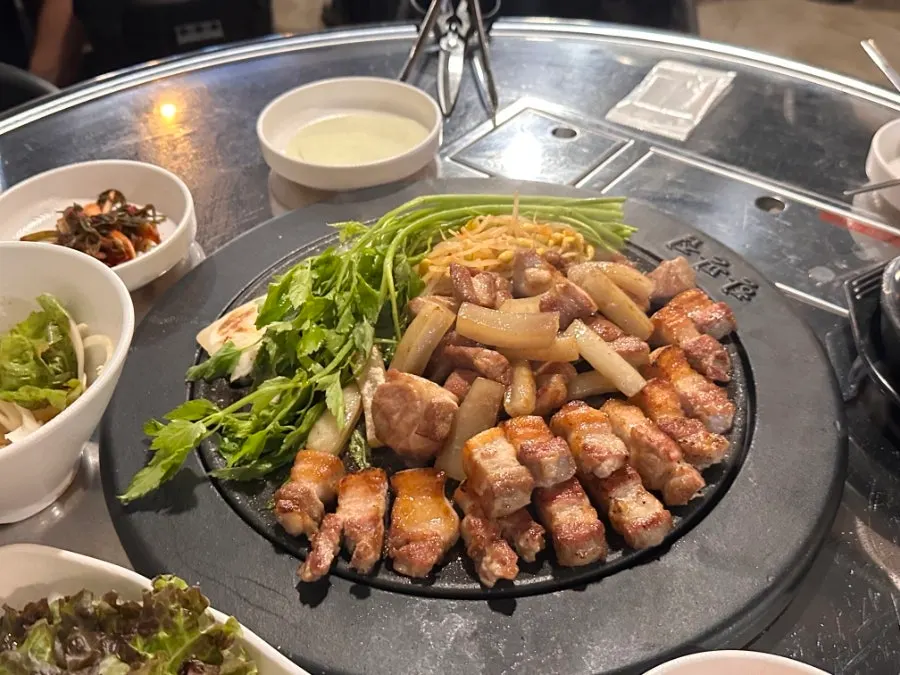 고기와 미나리가 익어가는 불판 근접 모습