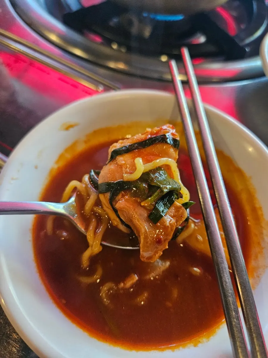 A bite of boneless dakbokkeumtang scooped up with broth