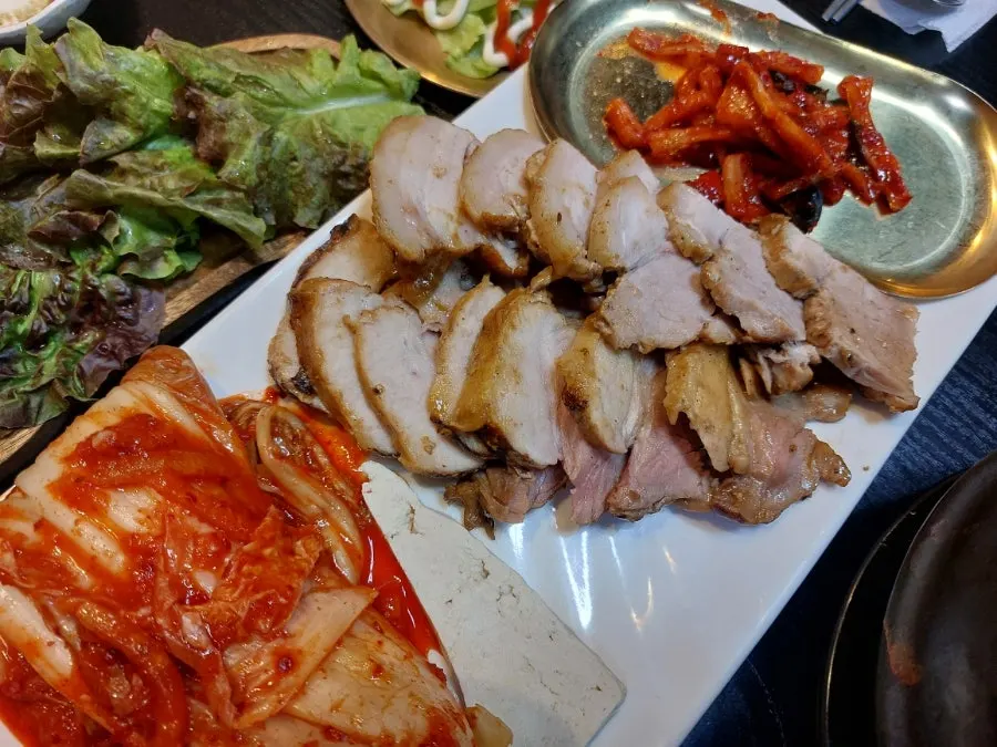 Close-up of bossam and accompanying side dishes