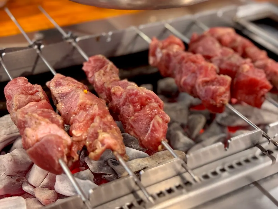 Lamb loin skewers rotating automatically on the grill
