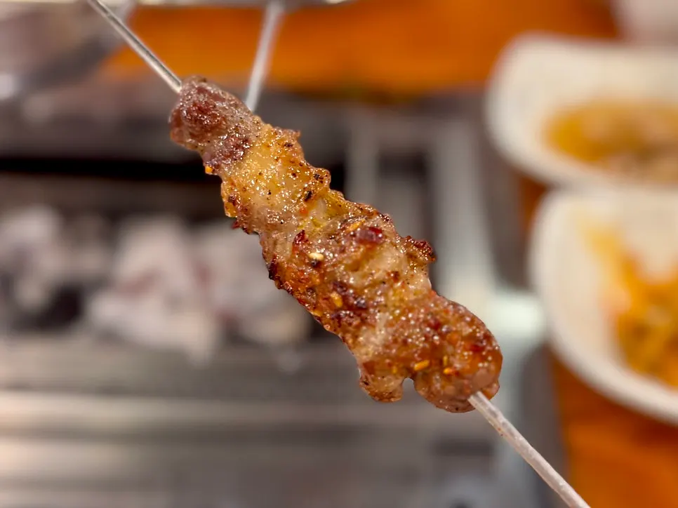Lamb rib skewers cooking on the grill