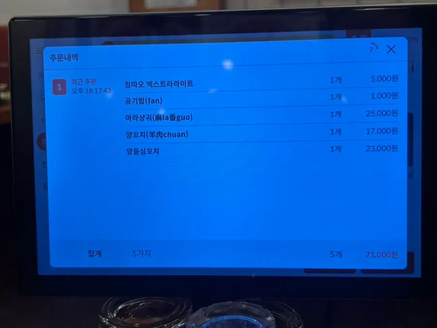 Menu notice explaining the 2-serving minimum for lamb skewers
